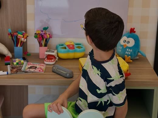 Criança utilizando o espaço de atividades do consultório odontopediátrico.